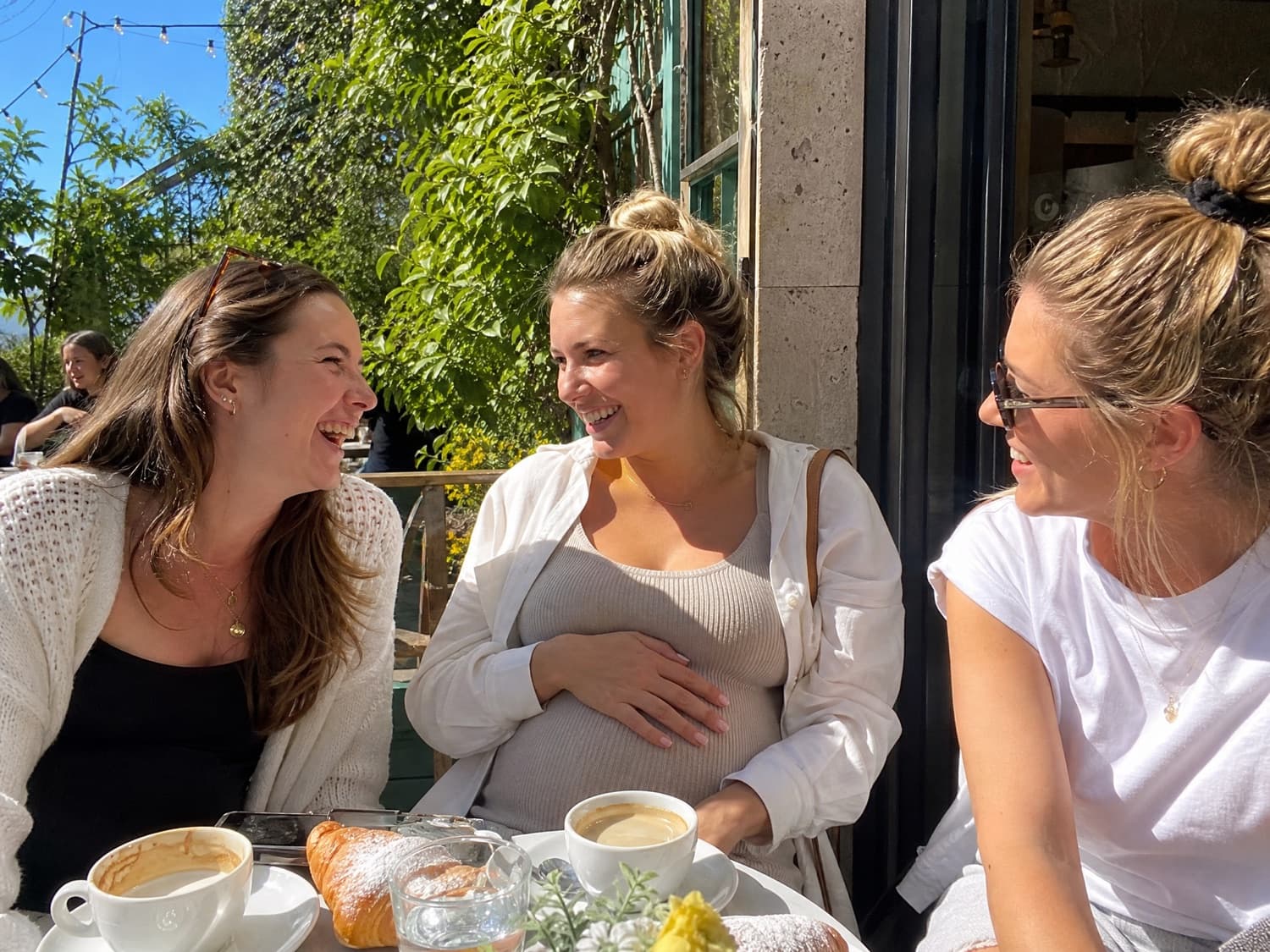 Surrogate mothers laughing together at an outdoor cafe