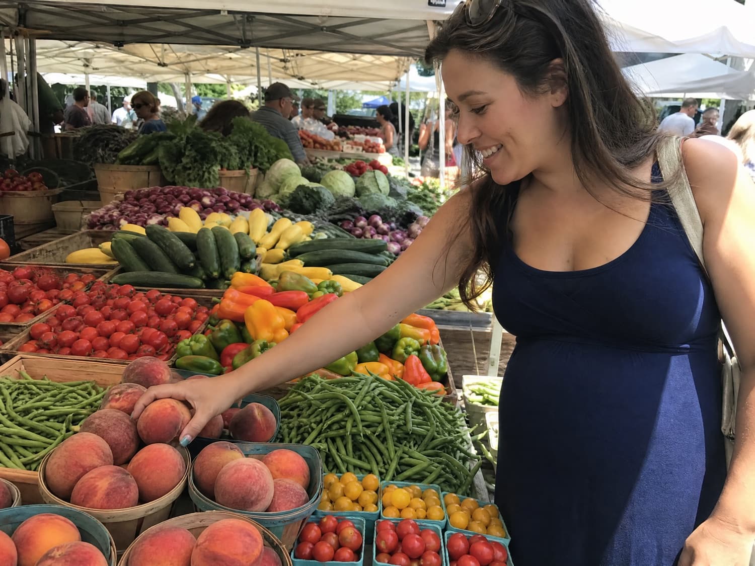 A pregnant surrogate mother at an open-air farmers market